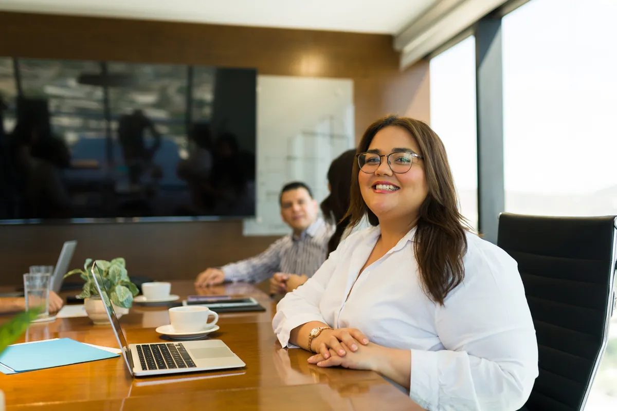 An employee smiling in a team meeting at work